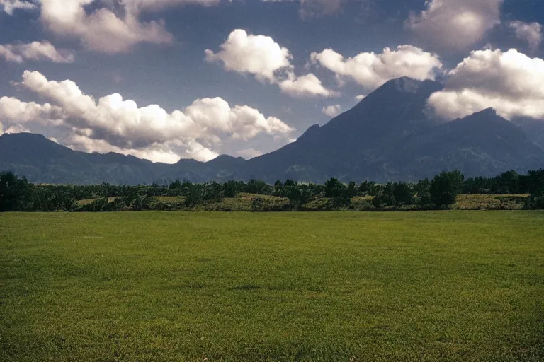 Prompt: film color photography, small mirror reflected clouds, long view of green lawn, no focus, mountains in distance, 35mm