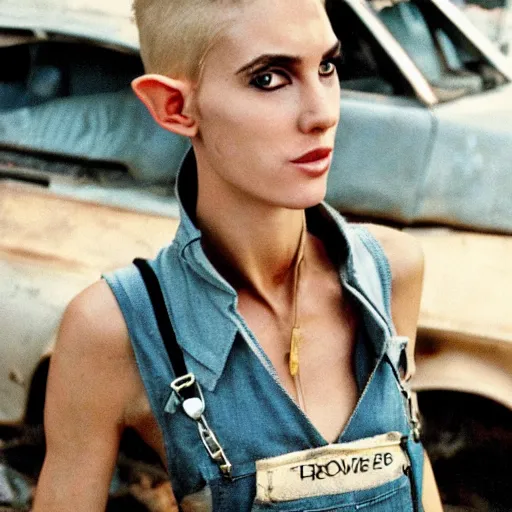 Image similar to a skinny female high-fantasy elf with a long face narrow chin and short spiky blonde hair wearing dark brown overalls and holding a bomb next to a destroyed car, gel spiked blond hair, narrow lips, high resolution film still, HDR color, photograph by Mario Testino