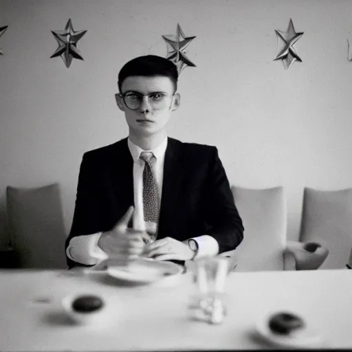 Image similar to A young man in a suit sits at a table , USSR logo in background, bokeh, cinestill, fine details