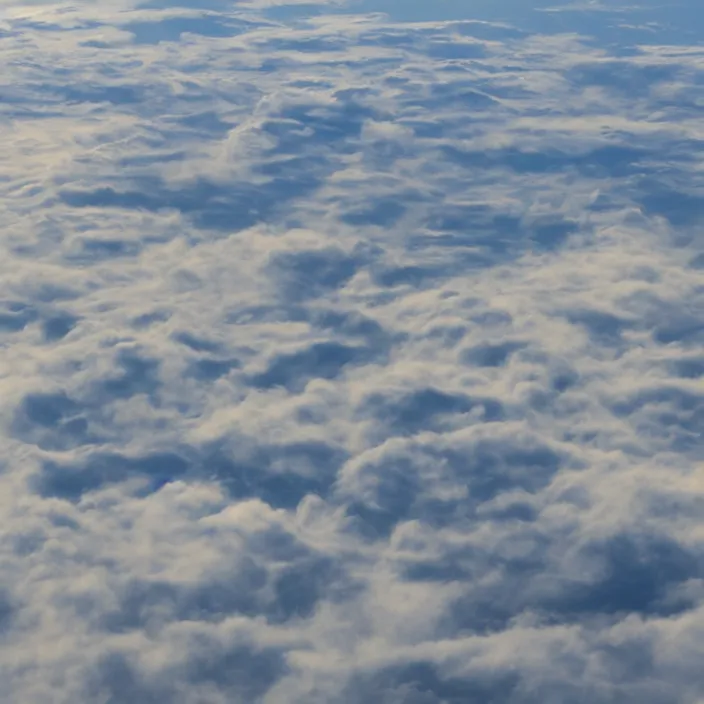 Image similar to Endless pale yellow clouds towering, seen from above, very detailed, 8k resolution