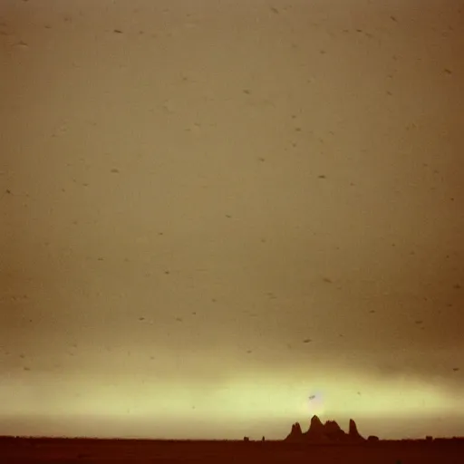 Image similar to photo of shiprock, new mexico during a snowstorm. a old man in a trench coat and a cane appears as a hazy silhouette in the distance, looking back over his shoulder. cold color temperature. blue hour morning light, snow storm. hazy atmosphere. humidity haze. kodak ektachrome, greenish expired film, award winning, low contrast,