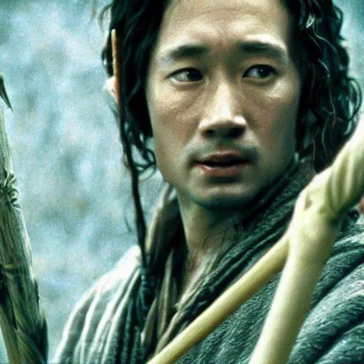 Image similar to a still from “ lord of the rings ” of a head and shoulders portrait of fei lung as a wizard with a wooden staff, photo by phil noto