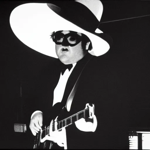 Image similar to john belushi wearing a black suit and black necktie and black fedora hat playing electric guitar in a darkened nightclub, 3 5 mm film still from 1 9 8 1, grainy.