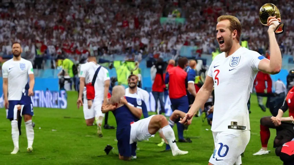 Image similar to Harry Kane wins the World Cup for England and lifts the Jules Rimet trophy. Harry Kane wears a white England football shirt with three lions on the badge