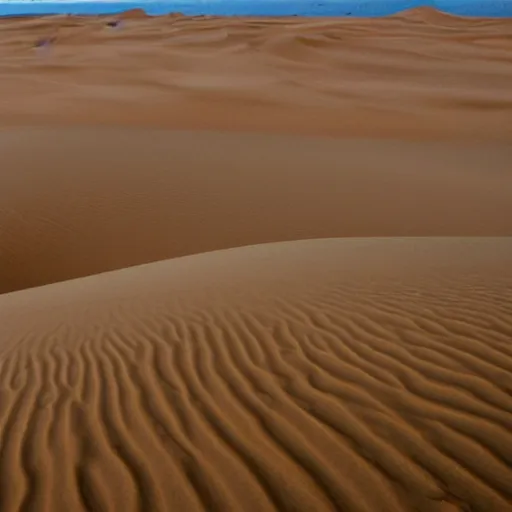 Image similar to a desert landscape like this one often features sand dunes. sand dunes, formed by the wind, come in many shapes and sizes. the direction of the wind can be indicated by the ripples in the dunes — the sides of dunes without ripples usually face the wind.