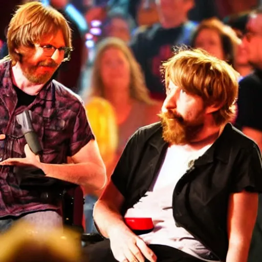 Prompt: trey anastasio sings a song while sitting on the arm of a wheelchair in front of a large crowd. behind him is jennifer aniston, who is holding a sign that says / i love you!