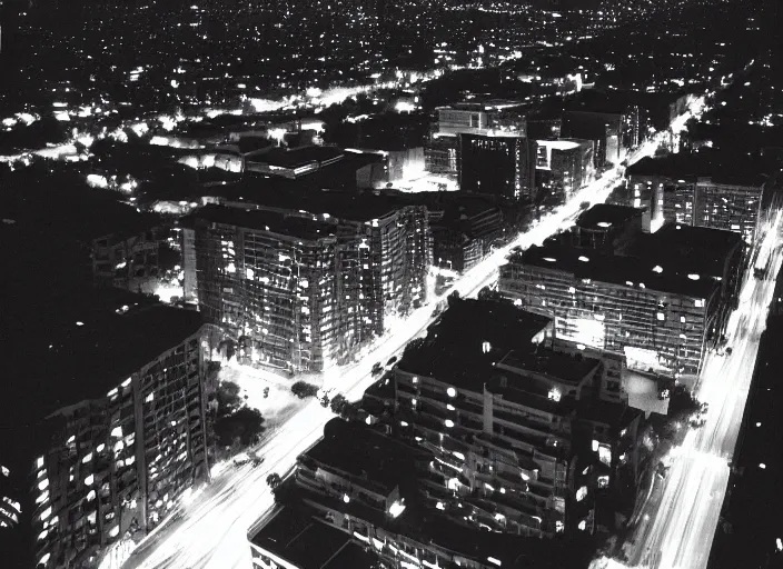 Image similar to a sprawling building complex seen from a dark parking lot in los angeles at night. 1 9 9 0 photo by james cameron. urban photography