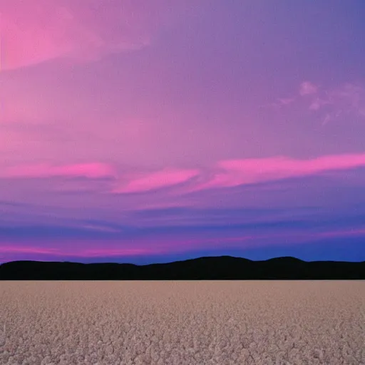 Image similar to rose and lavender colored sky with light pink clouds on a salt flat reflecting the pink sky dreamland