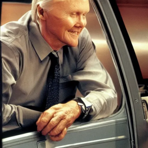 Image similar to john voight is sitting in a van, door open, looking at camera and smiling, he holds up his arms, showing his handcuffs