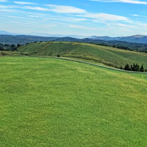 Image similar to a singular, green hill in the middle of the photo. no tree's are on the hill. the sky is a bright blue.