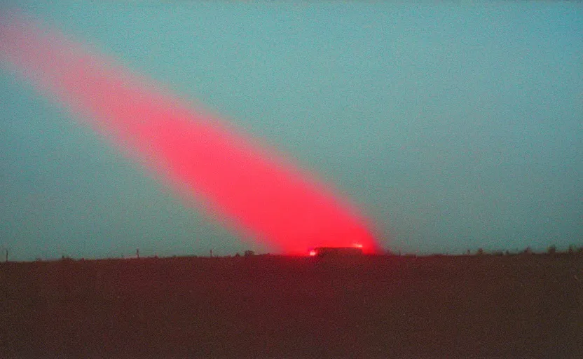 Prompt: red beam of light from lighthouse rotating over the field, night, unsettling, fire on the horizon, photo 1998