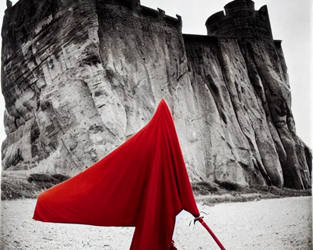 Image similar to by bruce davidson, by andrew boog faithfull redscale photography evocative. a beautiful kinetic sculpture of a horned, red - eyed, skeleton - like creature, with a long black cape, & a staff with a snake wrapped around it, standing in front of a castle atop a cliff.