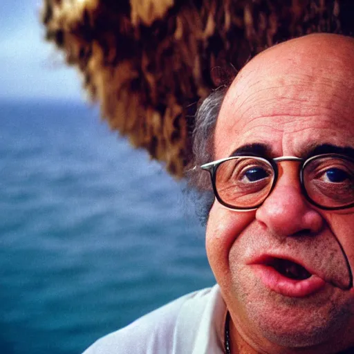 Prompt: close up portrait photography of a sweaty Danny Devito with bright blue eyes eating ham standing in front of ocean, 35mm, kodak film photo, steve mccurry