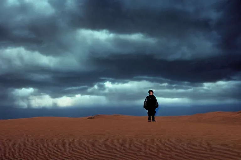 Prompt: a cinematic wide angle shot of a boy in the movie dune, in a serene vast desert, stormy weather, dry, film still, cinematic, movie still, dramatic lighting, by annie leibovitz