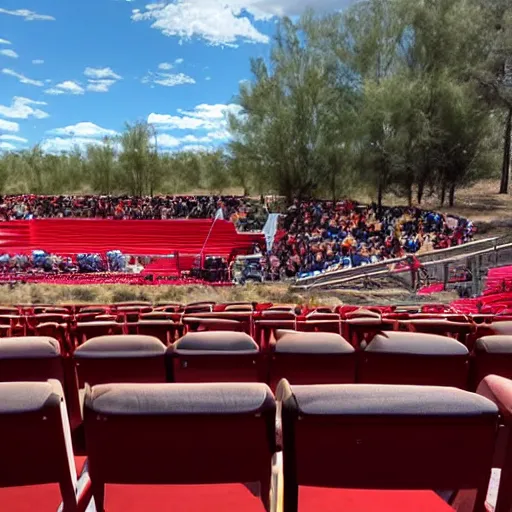 Prompt: pov seen from the stands of an outdoor show in a desert, the seats are in red velvet and comfortable, the stage is surrounded by wooden barriers