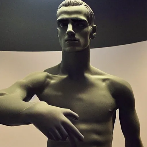 Image similar to “ a realistic detailed photo of a guy who is an attractive humanoid who is half robot and half humanoid, who is a male android, soccer player antoine griezmann, shiny skin, posing like a statue, blank stare, at the museum, on display ”