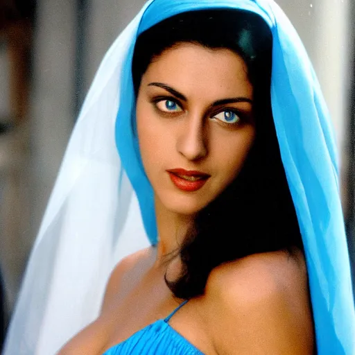 Image similar to young Monica Belluci as an Arab woman, tanned skintone, bright blue eyes, white transparent veil, glare face, light blue dress portrait