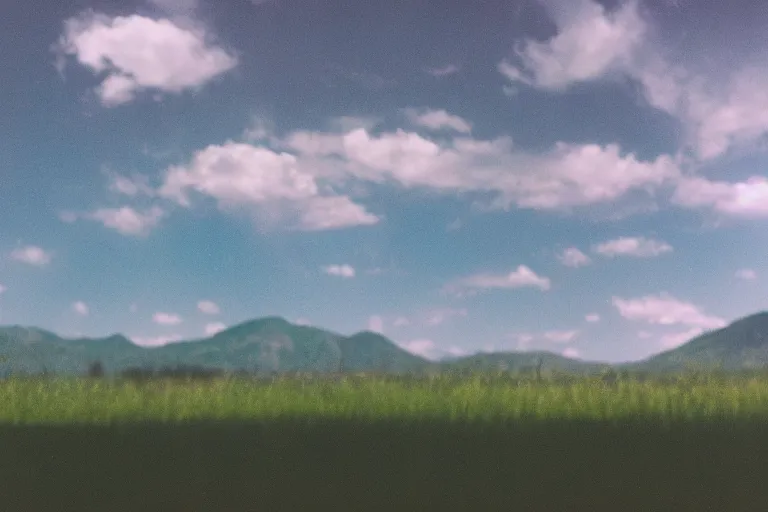 Image similar to film color photography, green lawn, small mirror reflected clouds, no focus, mountains in distance, 35mm