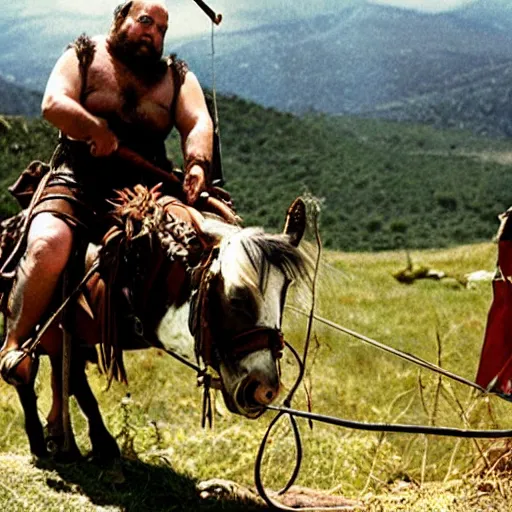 Image similar to Danny DeVito as a Hunnic barbararian on a horse, at the top of a hill overlooking a battleground campsite, film still