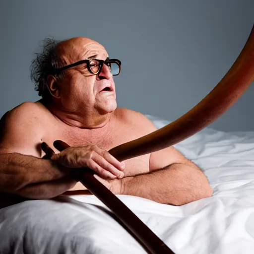 Image similar to Danny DeVito laying on a bed playing with his didgeridoo, cinematic, studio light, 8K,