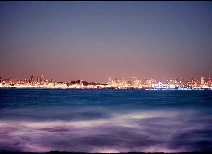 Prompt: photography, ocean at night, blue lighting, glowing city in the distance 35mm film,