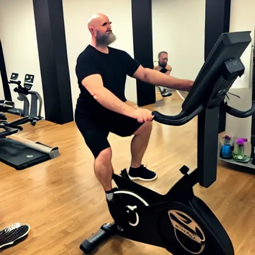 Prompt: chonky bald head with a grey closely shaven beard ethan van sciver working out vigorously on his peloton exercise bike