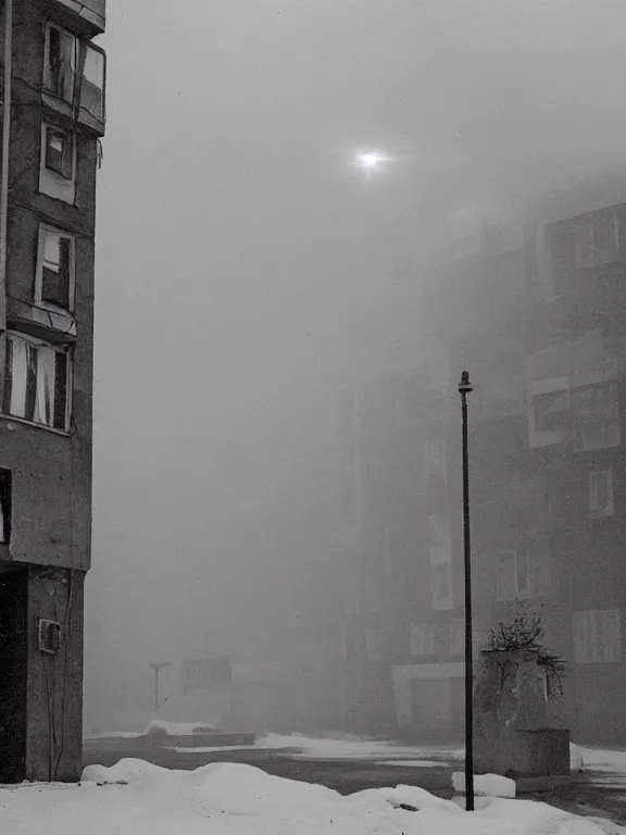 Image similar to film still of low soviet residential building in russian suburbs, lights are on in the windows, deep night, post - soviet courtyard, cozy atmosphere, winter, heavy snowб light fog, street lamps with orange light, several birches nearby, several elderly people stand at the entrance to the building