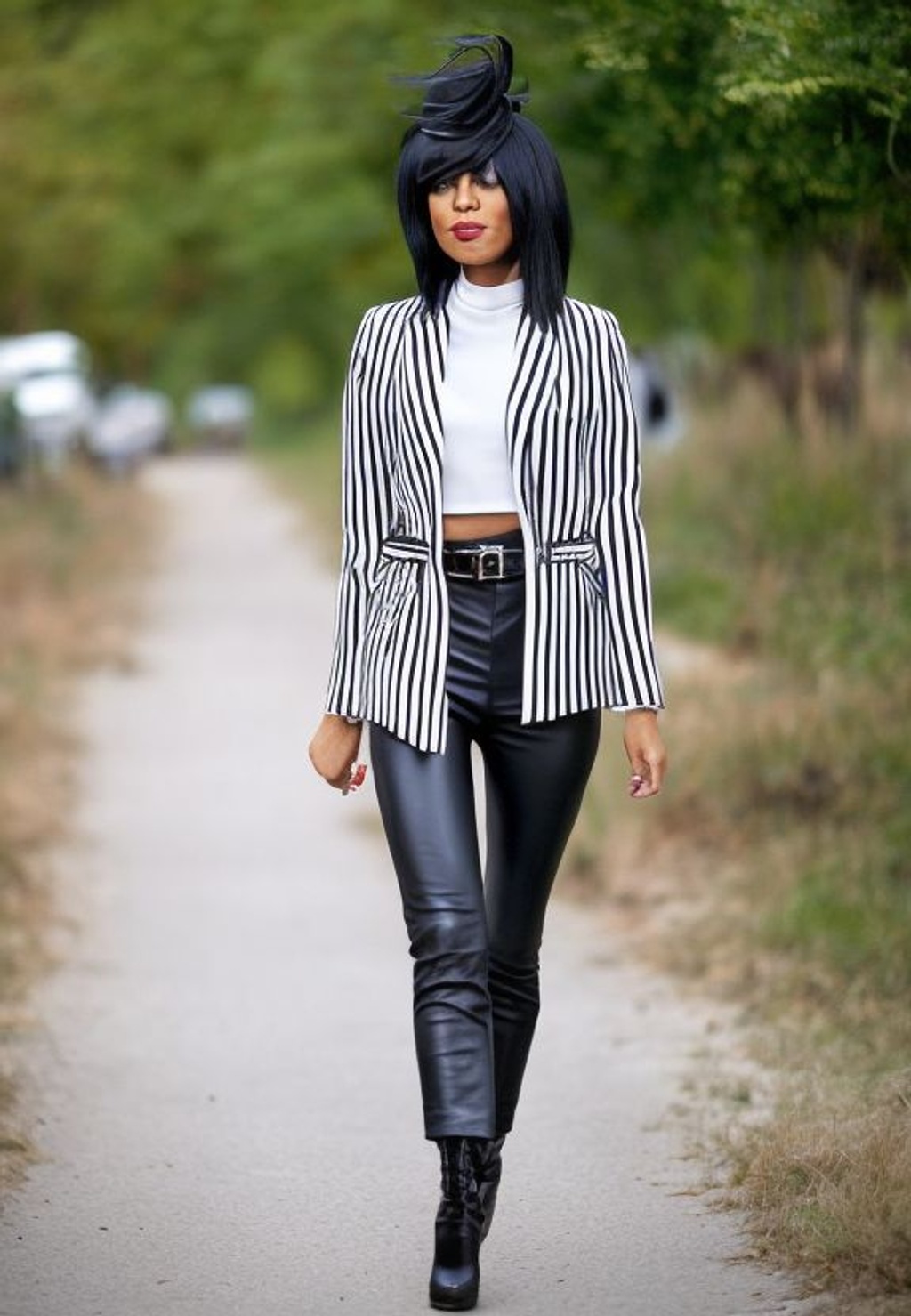 Pretty blonde woman smiling in urban background. Young girl wearing black  blazer jacket and striped trousers standing in the street. Pretty female  with straight hair hairstyle and blue eyes Stock Photo -