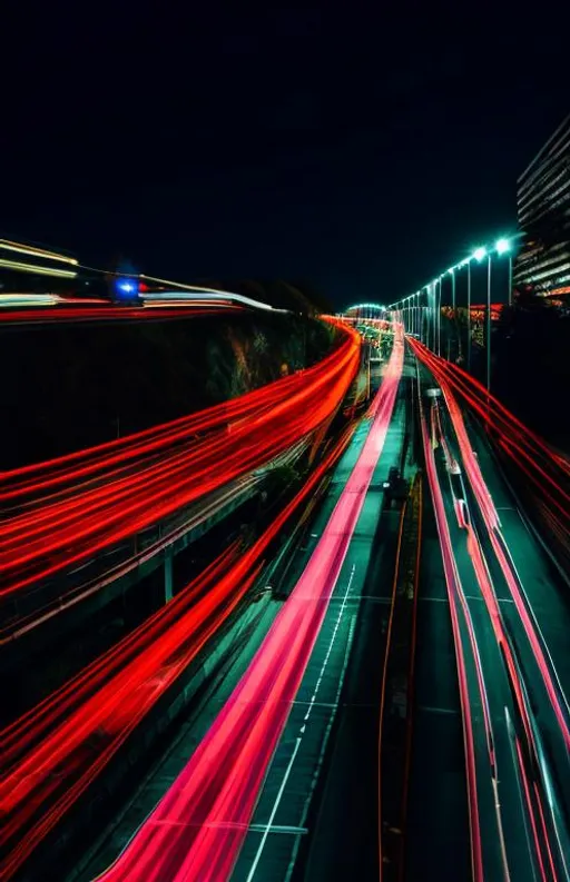 Prompt: Long-exposure night photography of traffic, with light trails

